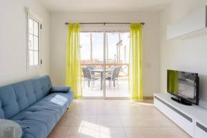 アデへにあるCosta Adeje Luxury Mangoの青いソファとテレビのあるリビングルーム