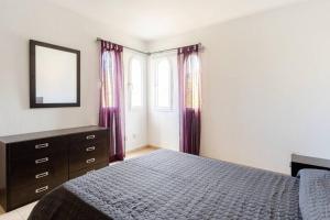 アデへにあるCosta Adeje Luxury Mangoのベッドルーム1室(紫色のカーテンと鏡付きのベッド1台付) +13枚の写真