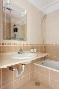 アデへにあるCosta Adeje Luxury Mangoの洗面台、浴槽、鏡のあるバスルーム