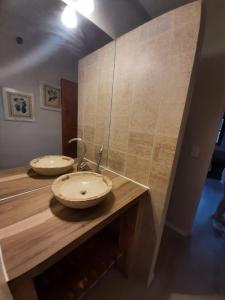 2 lavabos en un mostrador de madera en un baño en Hermosa casa frente al rio icho cruz 10 personas en Villa Icho Cruz