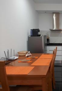 a wooden table in a kitchen with a refrigerator at Mar House Apartments in Praia