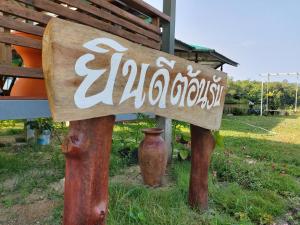 Khum Thong Resort في Takua Pa: وجود لافتة لحديقة بها مزهرية