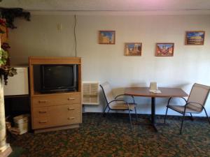 Zimmer mit einem Tisch und einem TV sowie einem Tisch und Stühlen in der Unterkunft Bennett Bay Inn in Coeur d'Alene