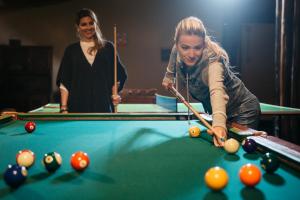 Empedrada Ranch & Lodge - Hotel Asociado Casa Andina في Caral: a woman playing a game of pool with a cue