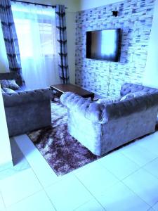 sala de estar con 2 sofás y TV en Standard Gardens 1-2-3 bedrooms Apartment Kisumu en Kisumu