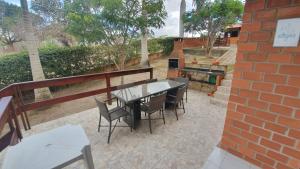 a patio with a table and chairs and a brick wall at Gravatá Country House in Gravatá