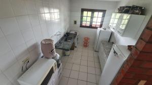 a small kitchen with a sink and a refrigerator at Gravatá Country House in Gravatá
