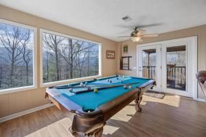 una mesa de billar en una habitación con ventanas en Happy Trails - Cobbly Nob Resort Home, en Gatlinburg