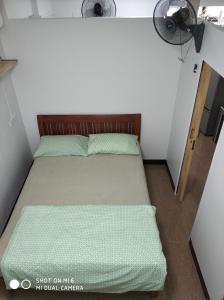 a small bedroom with a bed and a fan at 18floor condo close to MRTwith 2 bedrooms in Hua mak in Bangkok