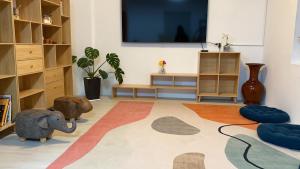 ein Wohnzimmer mit einem Flachbild-TV und einem Elefantenspielzeug in der Unterkunft 月光祝福民宿Moonlight Blessing Hostel in Chenggong