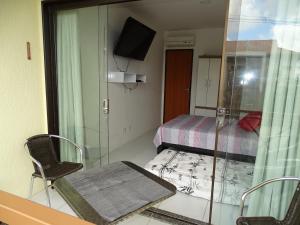 Habitación con mesa, cama y ventana en Flat Condomínio Fazenda Monte Castelo - Gravatá PE, en Recife