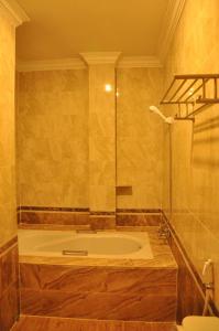 a bathroom with a tub with a glass shower at Angkor Comfort Hotel in Battambang