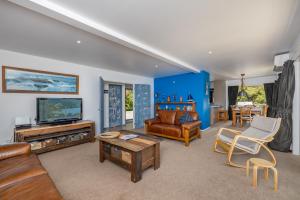 uma sala de estar cheia de mobiliário e uma televisão em Harbour View em Whangaroa