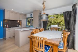 a kitchen and dining room with a table and chairs at Harbour View in Whangaroa