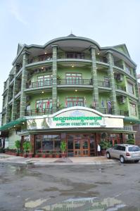 a green building with a car parked in front of it at Angkor Comfort Hotel in Battambang