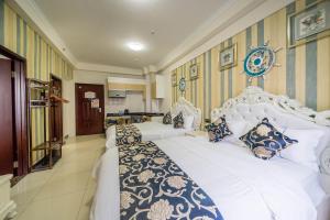 a bedroom with two beds with blue and white pillows at Guangzhou Laiste ApartHotel（Pazhou Exhibition Center Branch） in Guangzhou