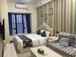 una camera d'albergo con letto e divano di Guangzhou Laiste ApartHotel（Pazhou Exhibition Center Branch） a Canton