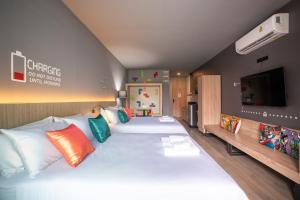 a bedroom with a large white bed with colorful pillows at TK Bed in Hat Yai
