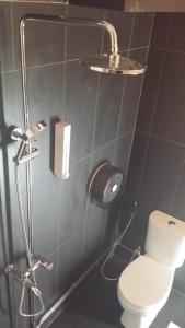 a bathroom with a white toilet and a shower at Chic Capsule Otel in Singapore