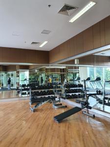 een fitnessruimte met een rij loopbanden en loopbanden bij Comfy Apartment Grand Sungkon Lagoon in Dukuhpakis