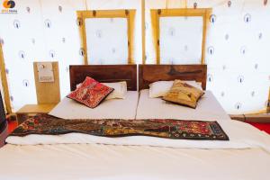una cama con almohadas encima en una habitación en Room Factory Hotels sam en Sām