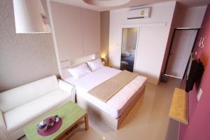 a small room with a bed and a table at Bearing26 Hotel in Bangna