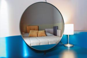 a mirror in a room with a bed and a couch at Hotel Eubea in Reggio Calabria