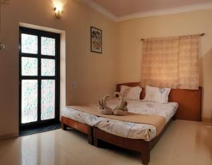 a bedroom with a bed with two stuffed animals on it at Mama Mids Home in Morjim