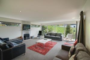 uma sala de estar com sofás e uma lareira em Highview Retreat em Queenstown