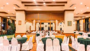 a banquet hall with green tables and white chairs at K Park Grand Hotel in Surat Thani