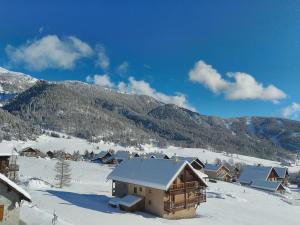 una casa en la nieve con montañas en el fondo en les Balcons de l'Izoard - la Marmotte en Arvieux