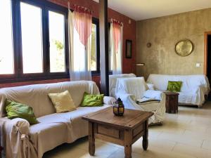 a living room with two couches and a coffee table at Hotel Finca Aldabra in Pinos Genil