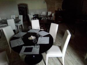 a dining room with a black table and white chairs at Hotel Collina di San Sisto in San Sisto