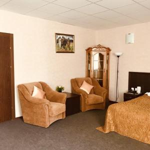 a hotel room with two chairs and a bed at Skazka Hotel Complex in Ulyanovsk