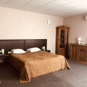 1 dormitorio con 1 cama grande y armario de madera en Skazka Hotel Complex, en Ulyanovsk