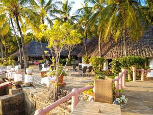 een resort met palmbomen en stoelen en een zwembad bij Fast Care Villa Bavaria in Mombasa