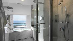 a bathroom with a shower and a glass shower stall at Hotel New Otani Makuhari in Chiba