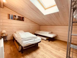 two beds in a room with a skylight at Maison Bois du Bassin in Andernos-les-Bains