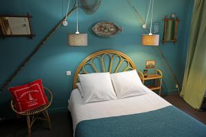 Hotel Auberge des Remparts في لافال: غرفة نوم بسرير وجدار ازرق