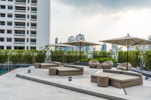 a patio with couches and umbrellas in a building at Oakwood Residence Sukhumvit Thonglor Bangkok in Bangkok