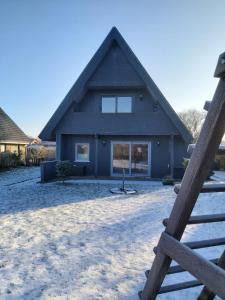a house with a gambrel roof in the snow at Fräulein Emma Lotta in Kronsgaard