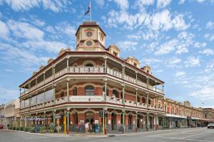 
a large building with a clock on the front of it at The National Hotel in Fremantle
