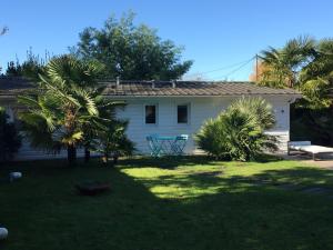 una casa blanca con una mesa en un patio en Petite Maison Andernos, en Andernos-les-Bains