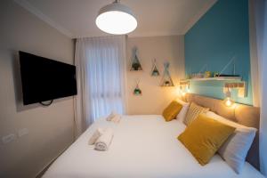 A bed or beds in a room at YalaRent Migdalor Boutique Hotel Apartments with Sea Views Tiberias