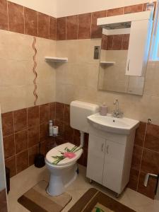 łazienka z toaletą i umywalką w obiekcie Katarina apartman w Hajduszoboszlo +7 zdjęć