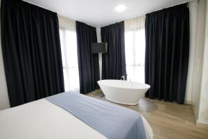 Schlafzimmer mit Badewanne und Bett in der Unterkunft Hotel Leo in Monesterio