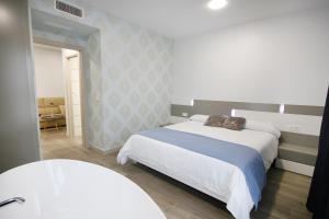 モネステリオにあるHotel Leoのベッドルーム1室(ベッド1台付)、バスルーム(シンク付)