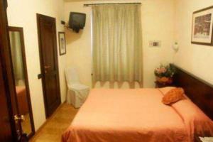 a bedroom with a bed and a window and a television at Hotel Collina di San Sisto in San Sisto