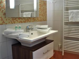 ein Bad mit einem Waschbecken und einem Spiegel in der Unterkunft Pension Zur Fährbrücke in Stralsund