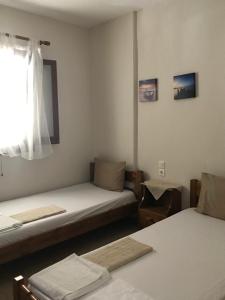 a room with two beds and a window at Ammos Studios and Apartments in Mikro